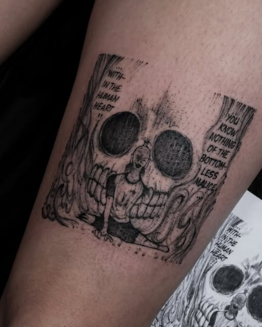 Jack Skellington skull tattoo with text fragments on upper arm, rendered in black ink with detailed line work and shading.