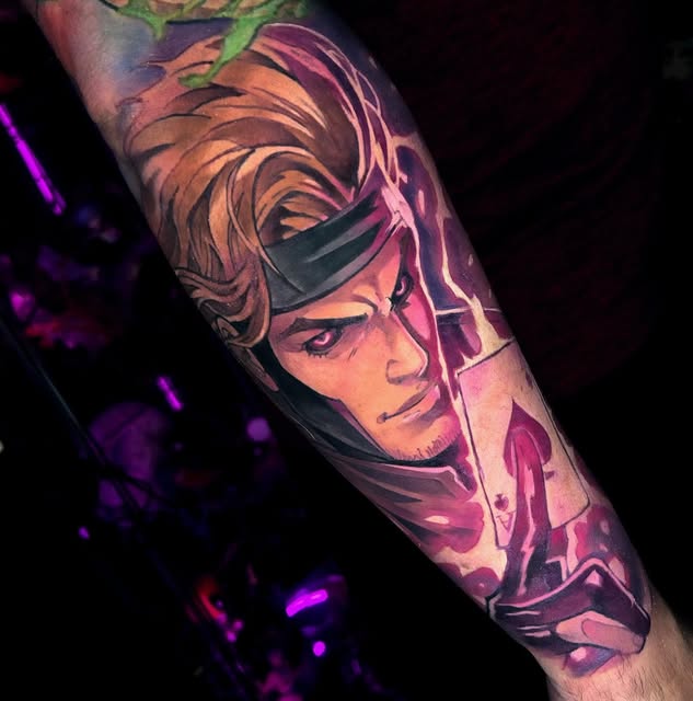 Colorful portrait tattoo on forearm of a character with flowing hair and facial markings in pink, orange, and purple tones under UV light.