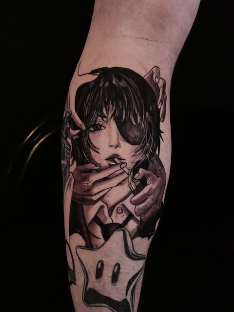 Anime girl character with short dark hair and bangs, hands near face, tattooed on inner forearm in black and grey ink.