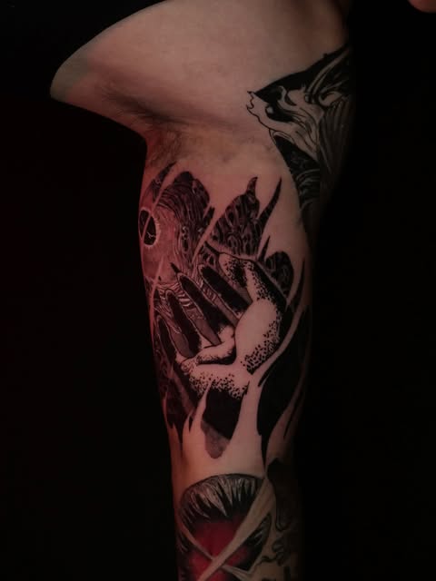 Dragon Ball Z character Shenron the wish-granting dragon in red and black ink on the inner forearm, with ornamental designs extending up the arm.