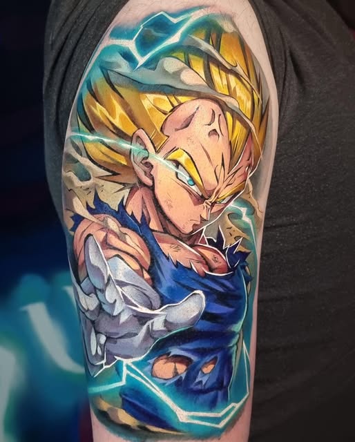 Vegeta from Dragon Ball Z tattoo on upper arm featuring blonde spiky hair, blue armor, and energy aura in yellow, blue, and teal colors.