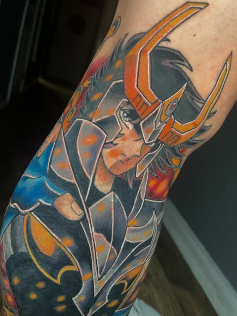 Deathwing the Destroyer from World of Warcraft tattooed on an arm, featuring the dragon's horned head and armored body in orange, blue, yellow, and black.