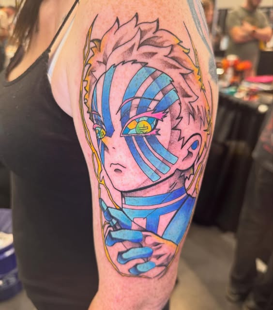 Jujutsu Kaisen character Yuji Itadori with pink spiky hair and blue striped face markings on upper arm tattoo, featuring yellow eye detail.