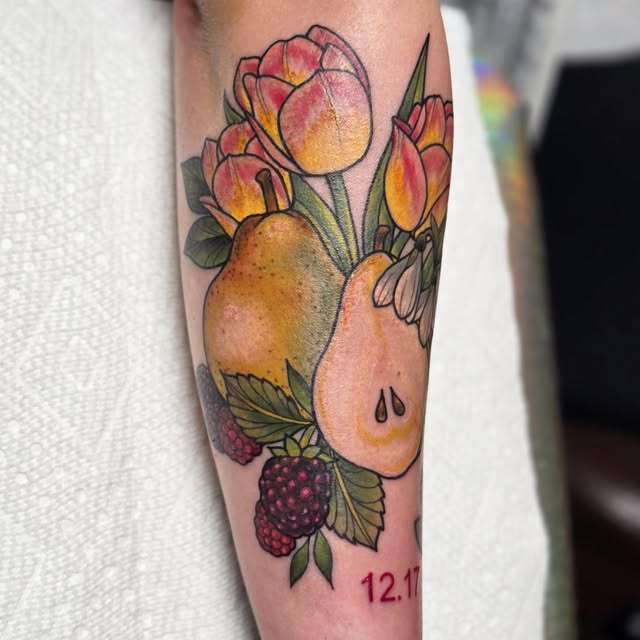 Colorful tattoo on forearm featuring red and yellow tulips, pears, raspberries, and a teardrop with date 12.11 below.