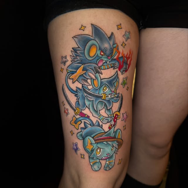 Pokémon evolution line tattoo on thigh featuring Litten, Torracat, and Incineroar stacked vertically with surrounding stars in blue, orange, red, and yellow inks.