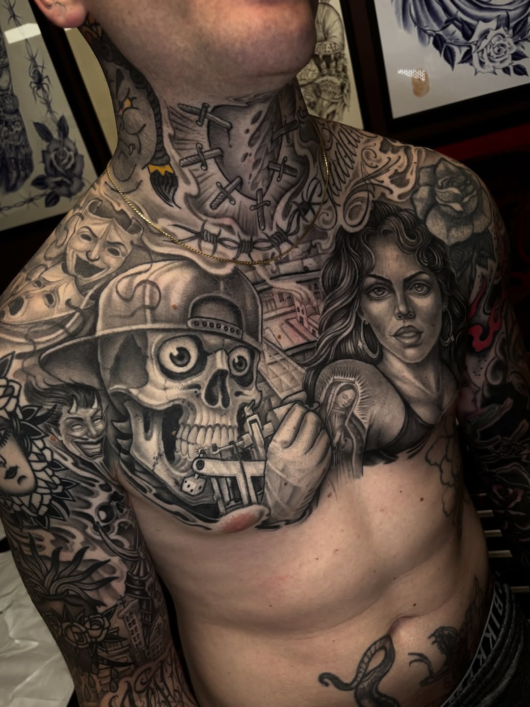 Black and grey chest tattoo featuring a skull wearing a hat, a female portrait, crosses, and ornamental designs on a shirtless man.