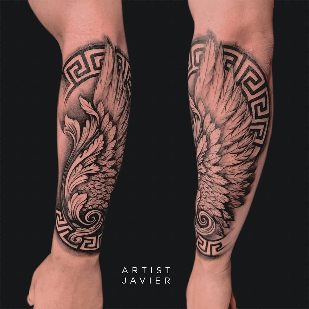 Pair of black and grey wing tattoos on both calves featuring detailed feather work with ornamental geometric patterns.