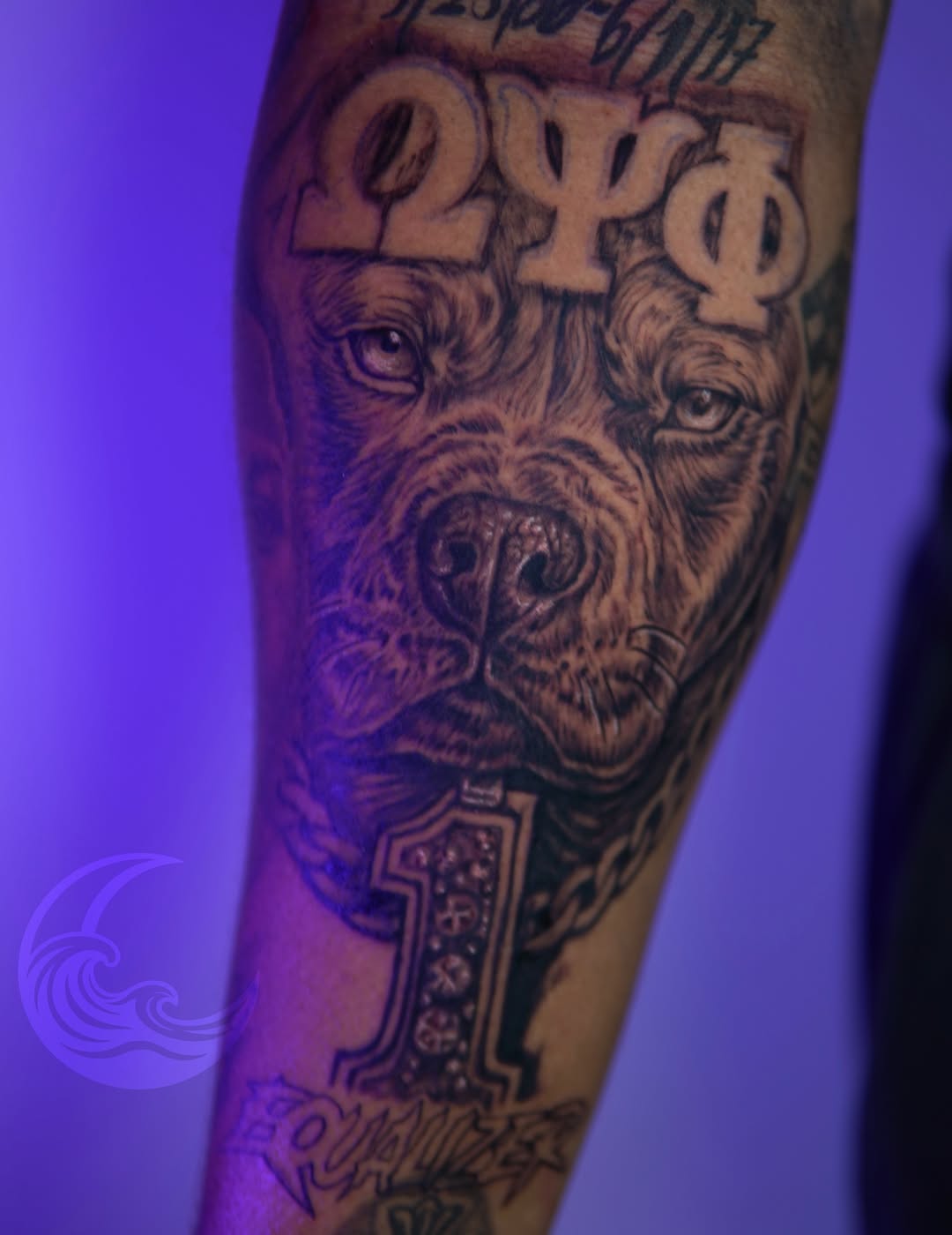 Black and grey bearded face tattoo with three eyes and ornamental dagger on forearm, detailed realistic shading.