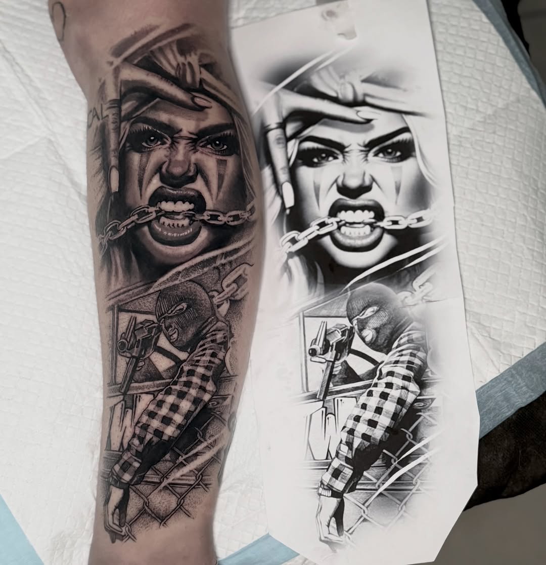 Black and grey portrait tattoo of an angry man with chain through mouth, with armed figure below, shown on arm next to sketch design.