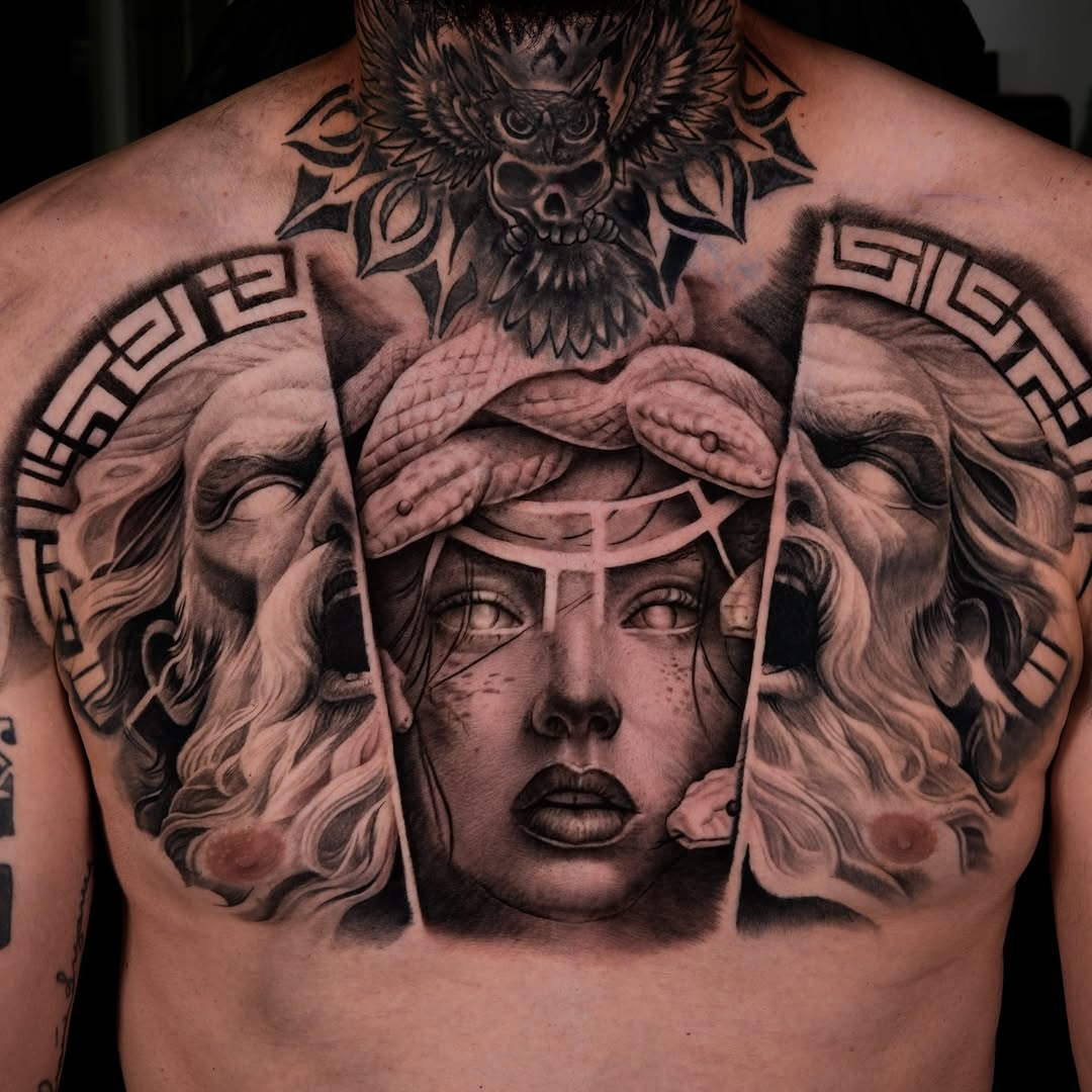 Photorealistic portrait of a female face with serpents and owl motif in black and grey on chest and shoulders.