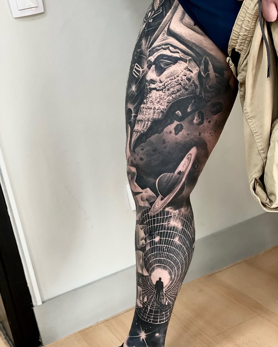 Full leg sleeve featuring a bearded face with ornate beard detail, planetary elements, and a geometric tunnel design in black and grey.