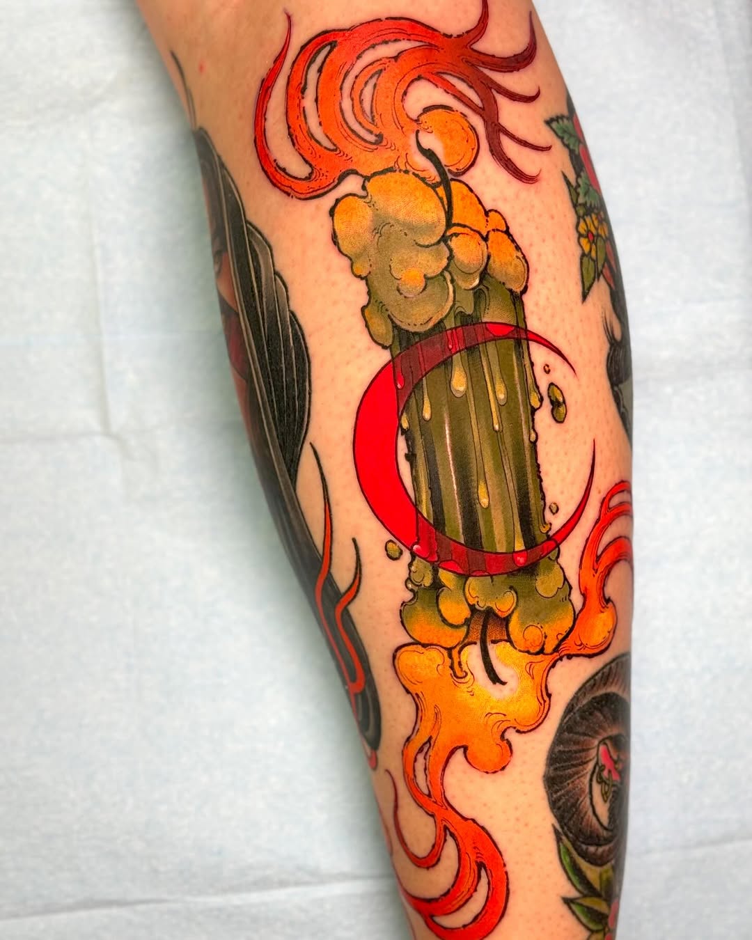 A colorful beer mug tattoo with overflowing foam and flames on the calf, featuring red, orange, and gold tones.