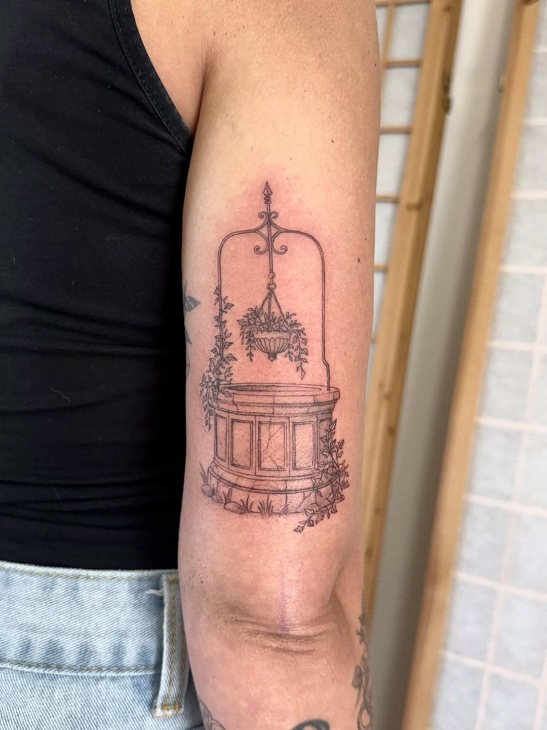 Ornate birdcage with hanging chandelier and climbing vines, rendered in delicate linework on the upper arm.