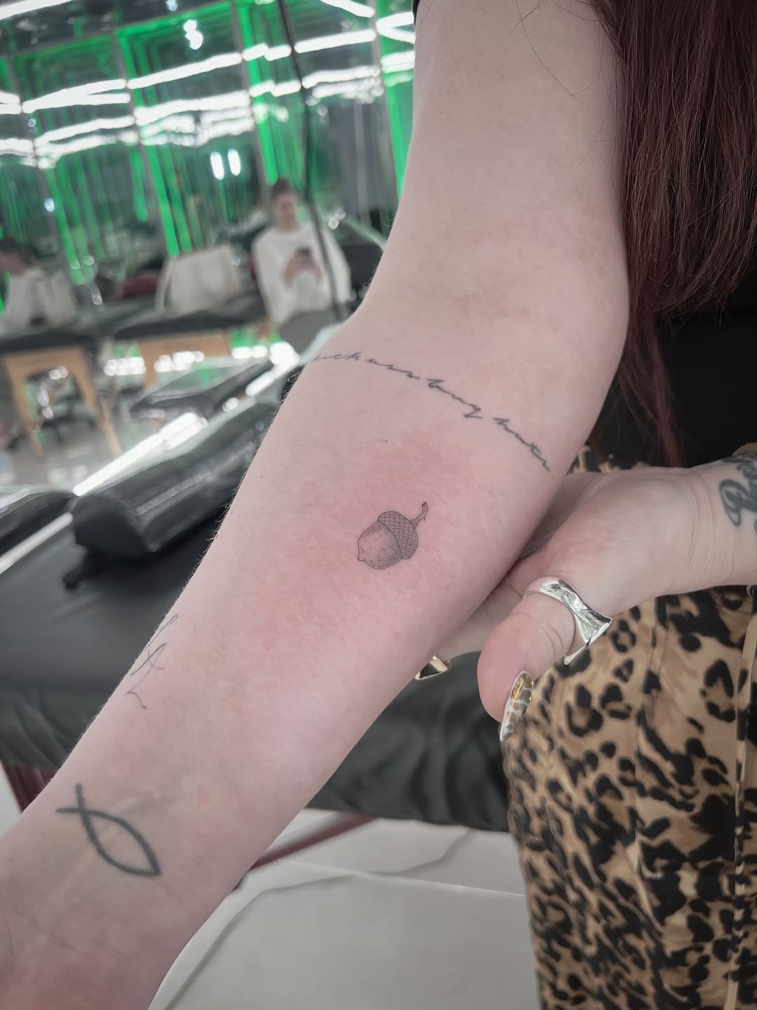 Small acorn with fine linework on inner forearm, minimal shading, delicate single-needle style.