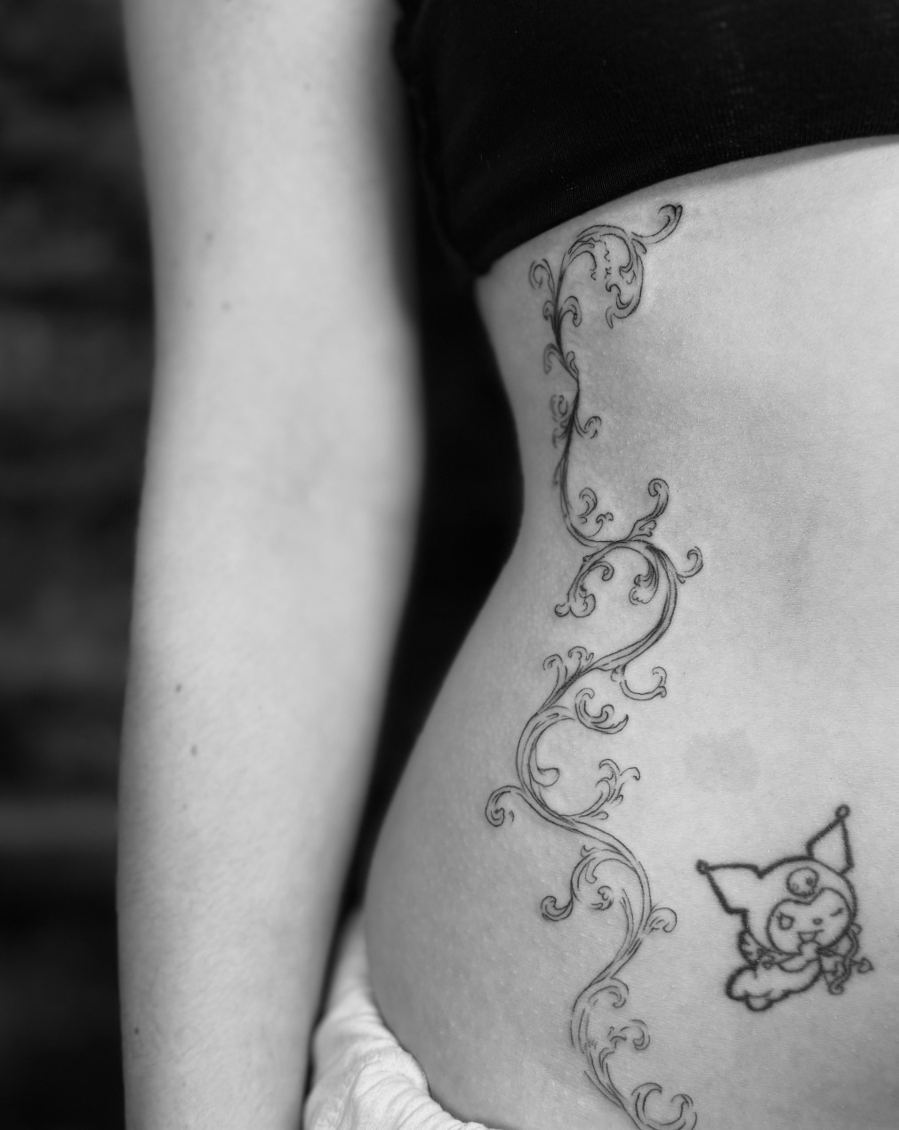 Ornamental scrollwork with delicate flourishes running vertically down the ribs, paired with a small Pokémon character (Espeon) at the lower end.