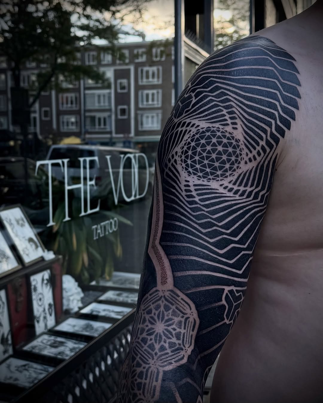 Geometric mandala-inspired sleeve with concentric wavy lines and symmetrical dotwork pattern, creating optical depth on upper arm.