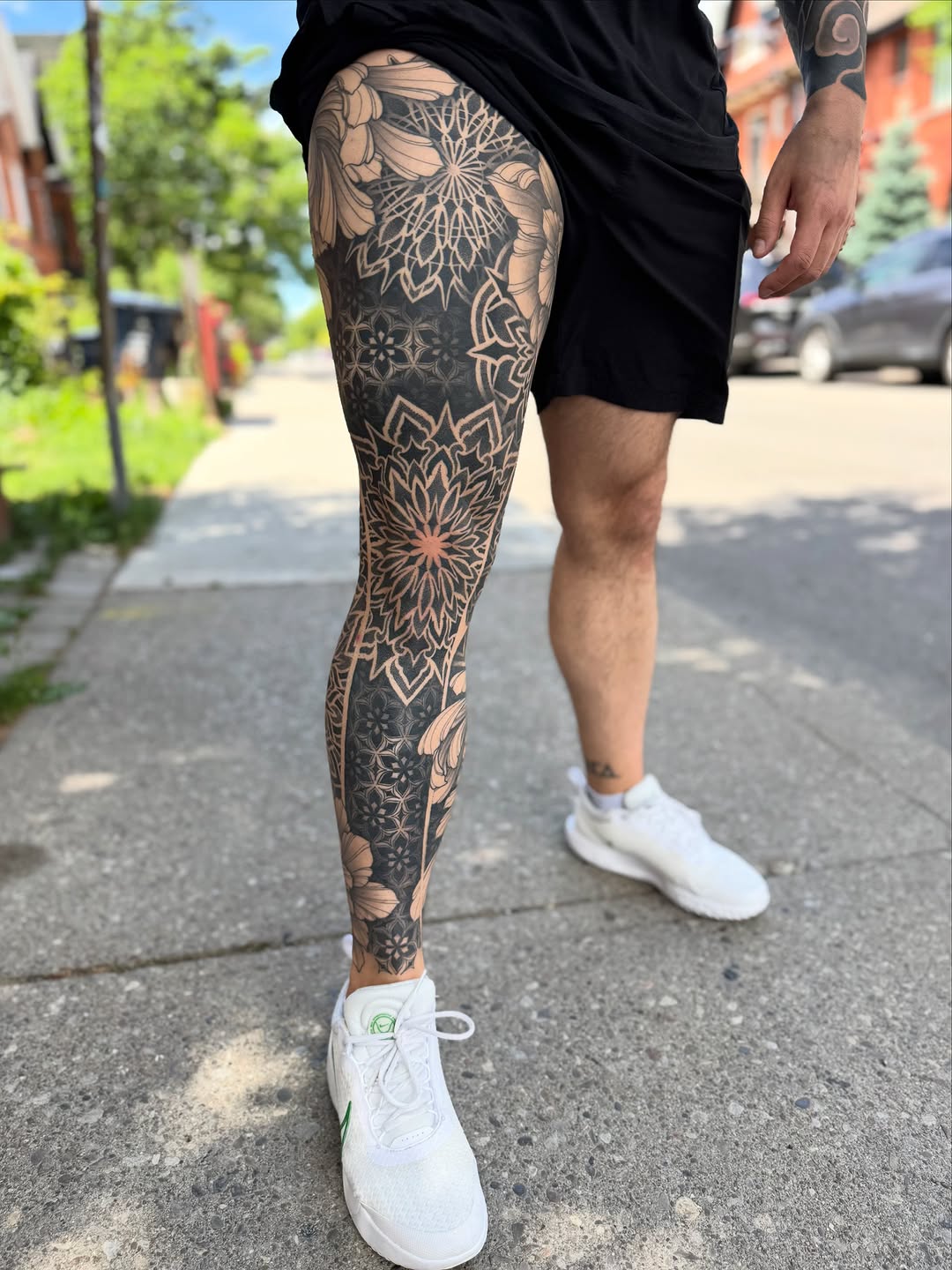 Full-leg mandala and floral geometric tattoo sleeve with intricate dotwork stippling and symmetrical ornamental patterns in black and grey.