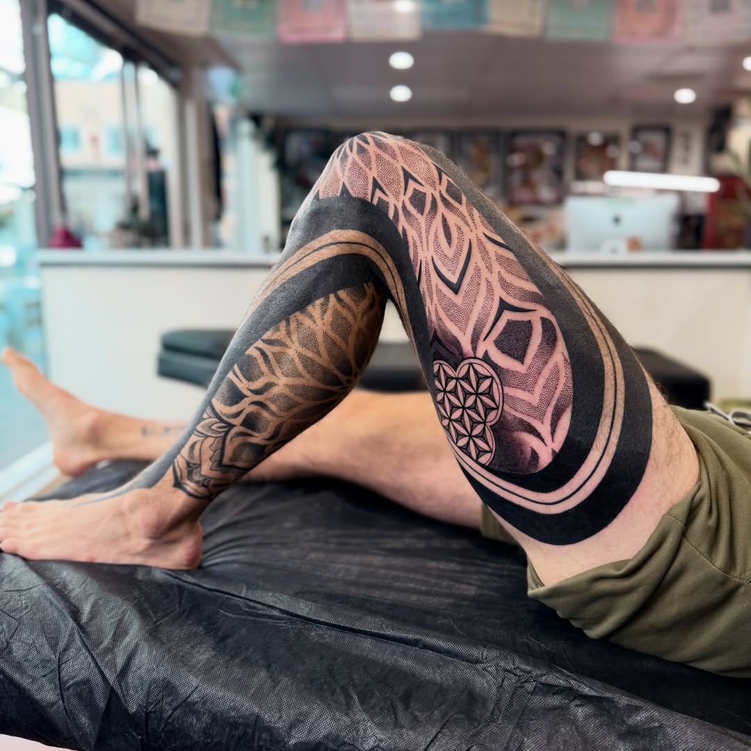 Full leg sleeve with geometric patterns, mandala motifs, and symmetrical linework in black and mauve tones.