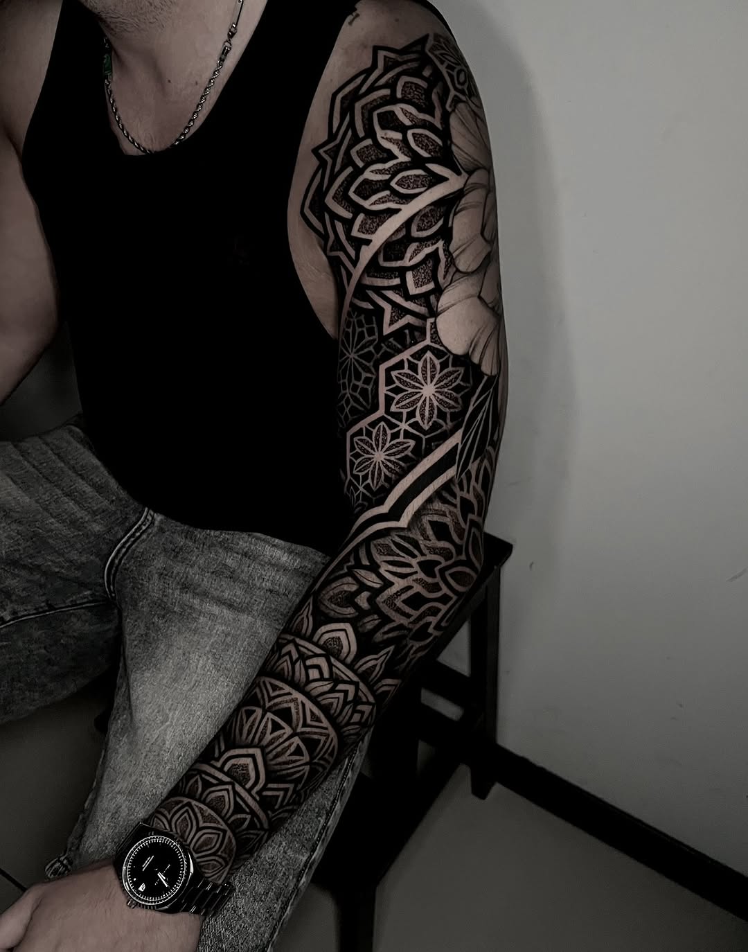 Full sleeve mandala and geometric floral pattern with intricate dotwork and symmetrical linework covering the arm.