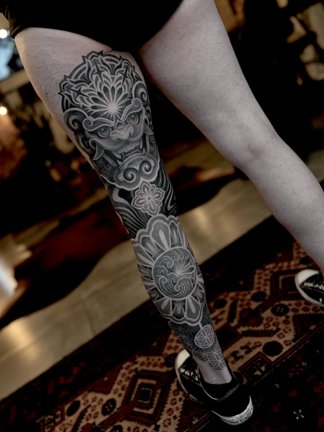 Full leg sleeve tattoo featuring ornate mandalas, floral motifs, and symmetrical geometric patterns in black and grey.