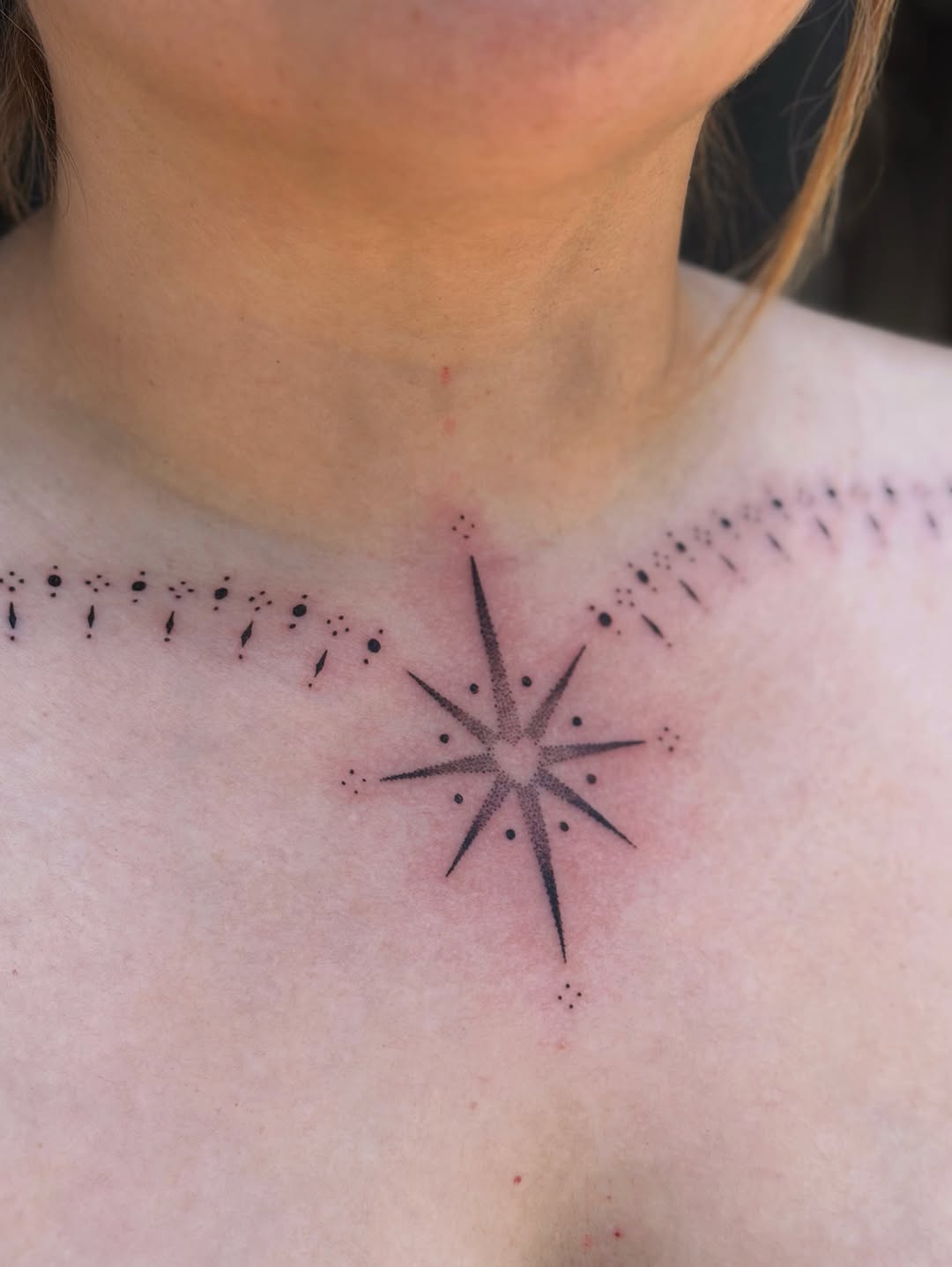 Eight-pointed star with dotwork stippling and radiating lines on the chest, flanked by decorative dot patterns on both sides.