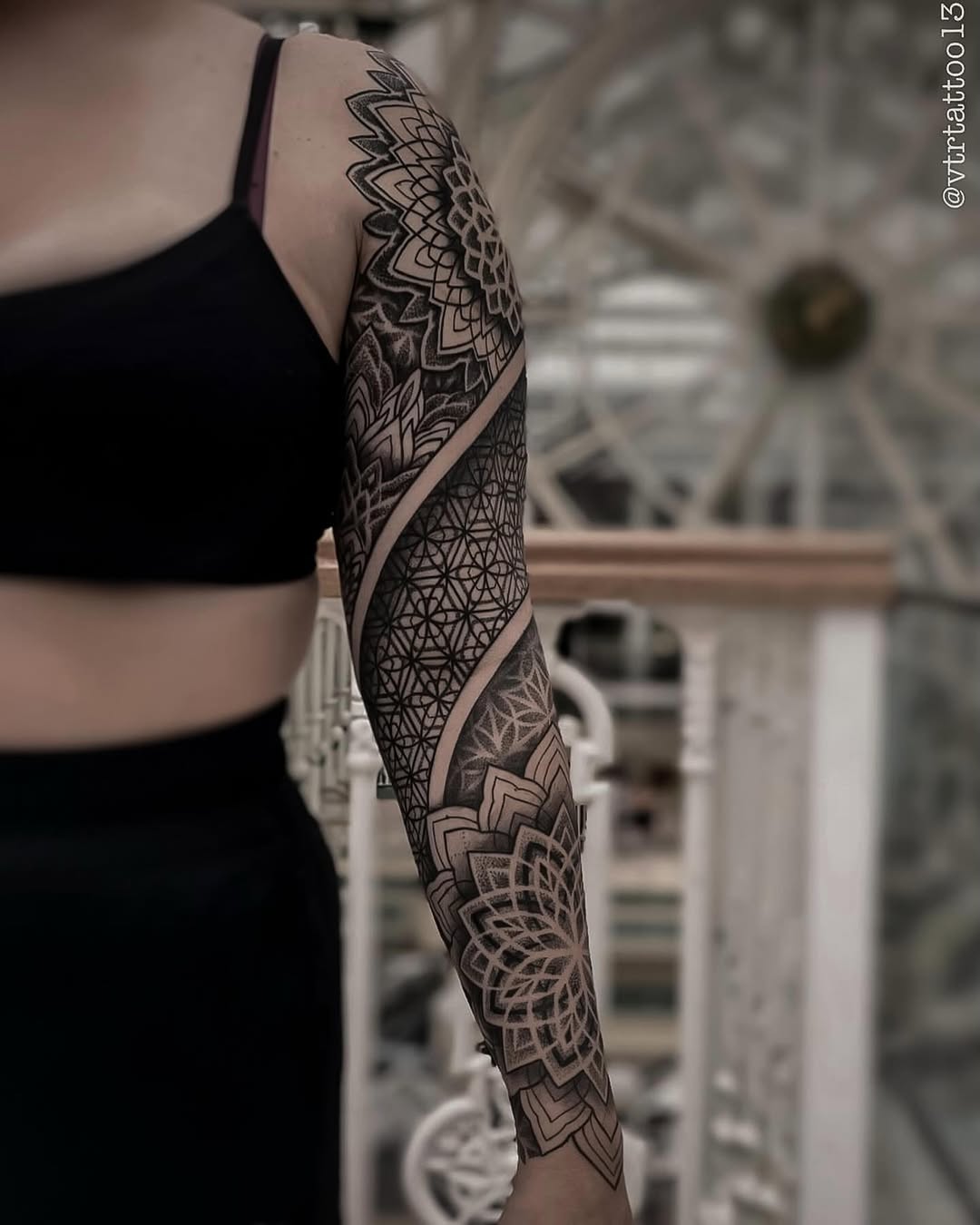 Full sleeve tattoo featuring geometric mandalas, dotwork patterns, and ornamental symmetrical designs in black ink on the arm.