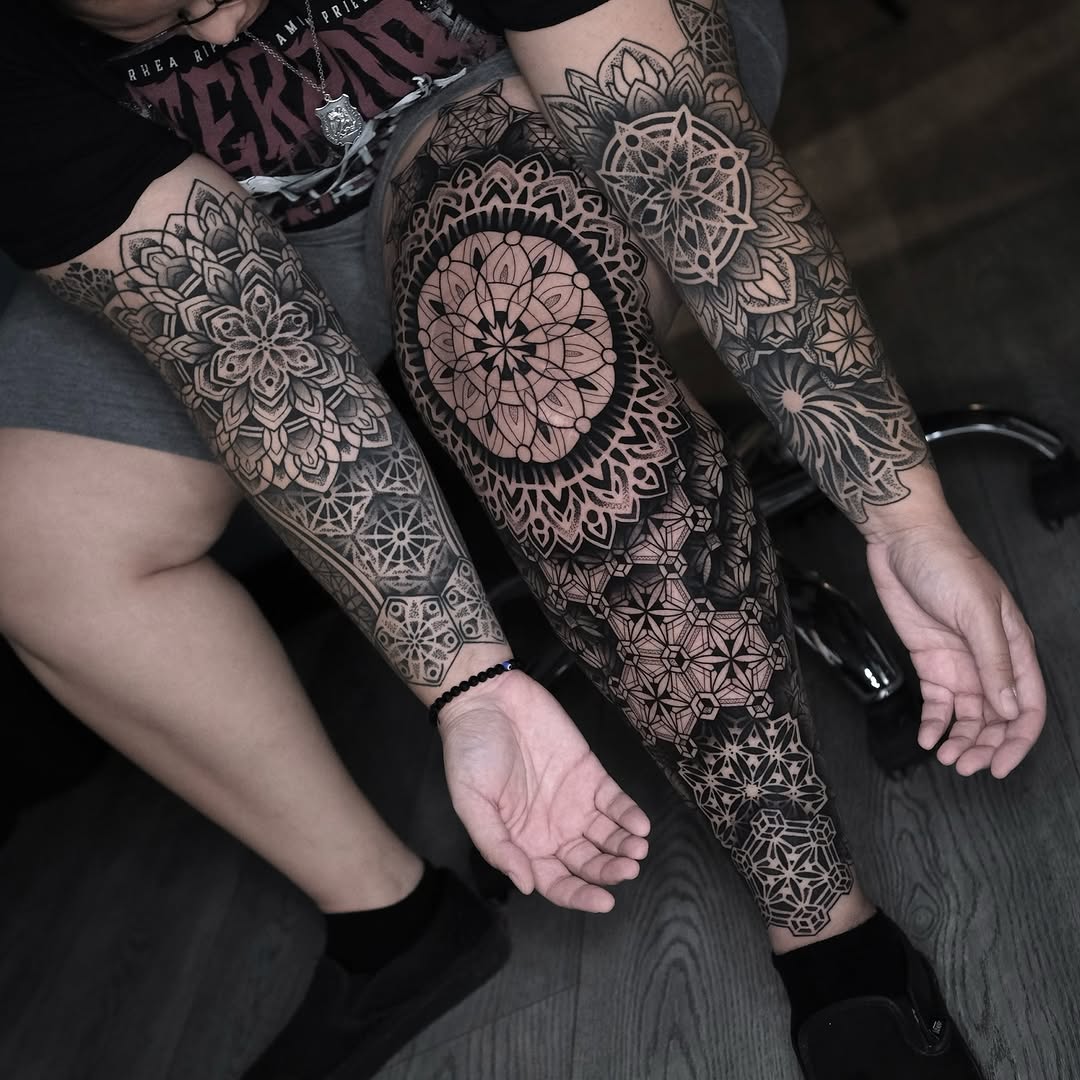Intricate mandala and floral geometric patterns covering both forearms with symmetrical dotwork and linework design.