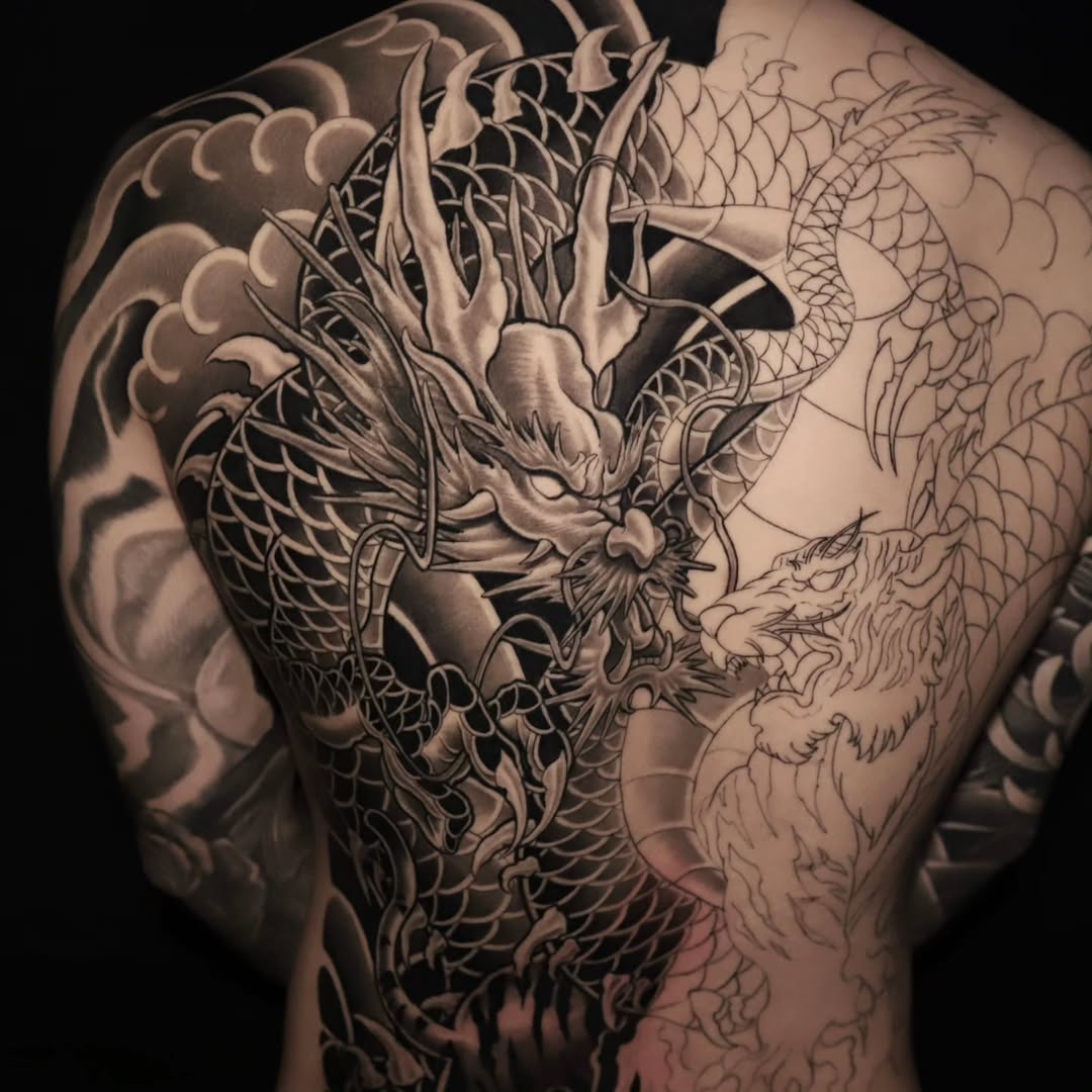 Large-format dragon with scaled body, ornate horns, and flowing composition covering the upper back.