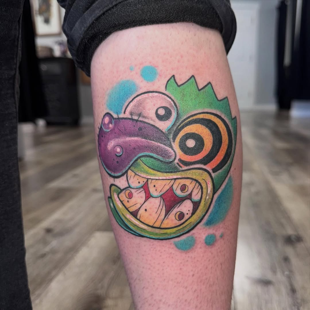 Colorful cartoon-style maneki-neko (lucky cat) with raised paw, green spiky hair, orange and purple accents on calf.