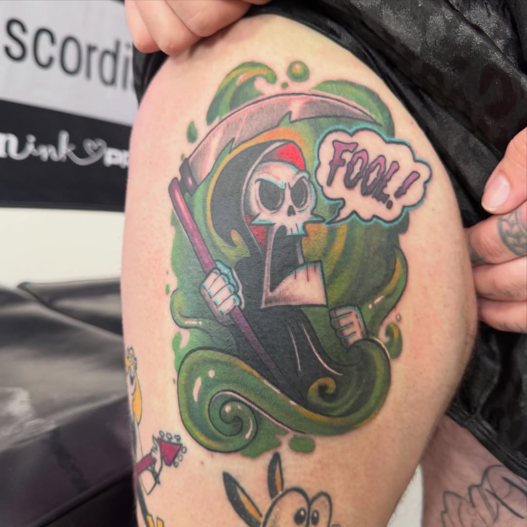 Colorful cartoon grim reaper with red Santa hat saying 'Fool!' on upper arm with green swirling background and ornamental details.